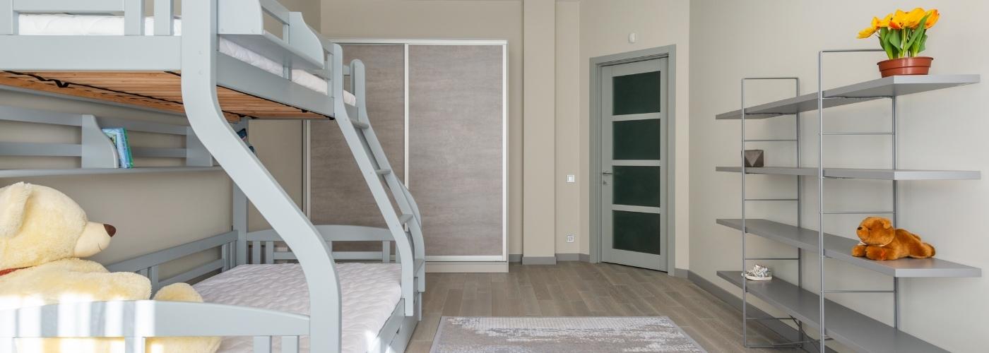 Grey triple bunk bed in a bedroom setting