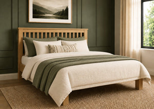 Amsterdam solid oak bed frame with slatted headboard and natural and green bedding.