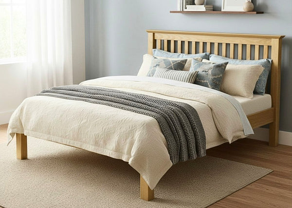 Barcelona LFE Bed: Natural pine low foot end bed with slatted headboard, cream bedding, and grey throw.