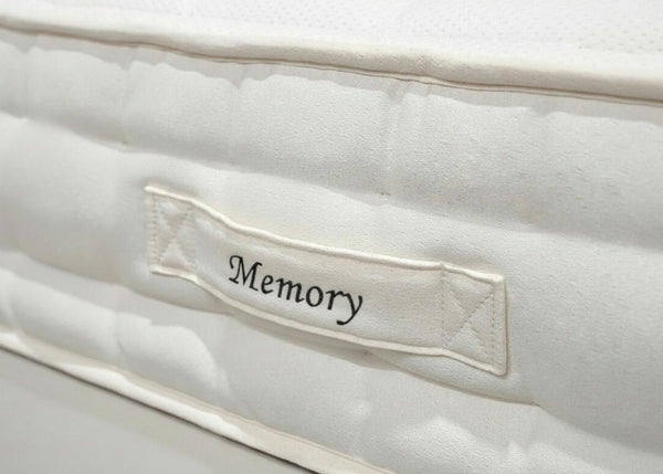 Close-up of a white Brick 'Memory' mattress with a side handle featuring "Memory" in script.