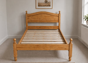 Dusseldorf Pine Bed: Natural solid pine bed frame with curved headboard, footboard, and turned posts, featuring solid wooden slats.
