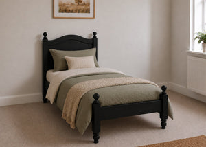 Dusseldorf Pine Bed frame with a natural finish, curved headboard, turned posts, and solid wooden slats in black stain and single size.