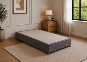 Single reinforced charcoal upholstered divan base with non-slip top and silver feet.