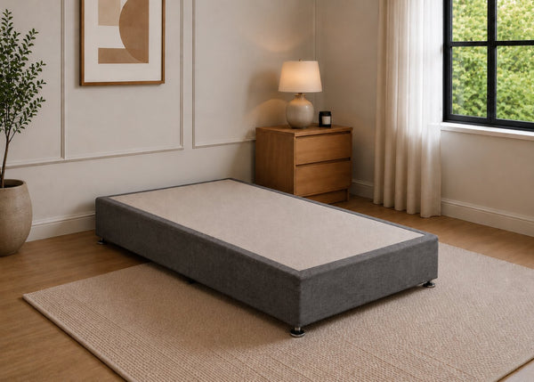 Single reinforced charcoal upholstered divan base with non-slip top and silver feet.