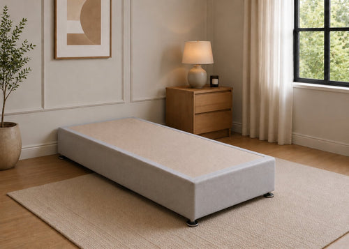 Single reinforced grey upholstered divan base with non-slip top and silver feet.