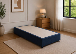 Single reinforced navy blue upholstered divan base with non-slip top and silver feet.