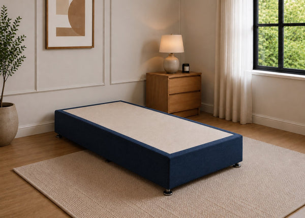 Single reinforced navy blue upholstered divan base with non-slip top and silver feet.