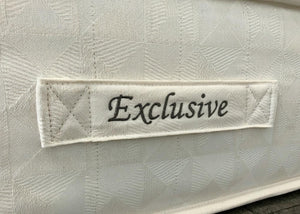 Close-up of a white textured Brick 'Extra Deep' Single mattress with an "Exclusive" label.