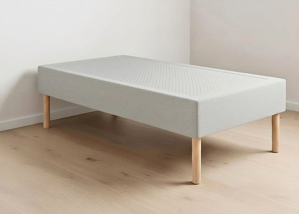 Grey linen upholstered shallow divan base with wooden legs and non-slip top.