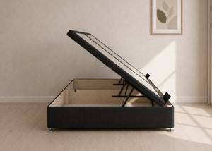 Black fabric side lift ottoman bed with thick corner posts and reinforced storage base, open to show gas-assisted mechanism.