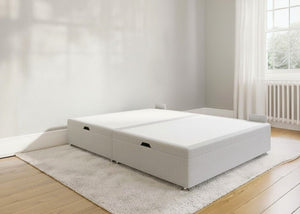 Light grey fabric side lift ottoman bed with thick corner posts and reinforced storage base.