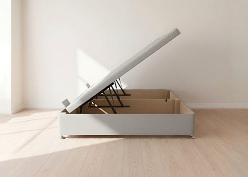 Light grey fabric side lift ottoman bed with thick corner posts, reinforced storage base, and gas-assisted lift mechanism.