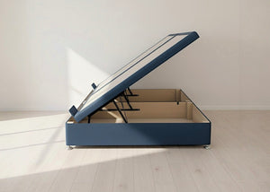Blue fabric side lift ottoman bed with gas-assisted mechanism, open to reveal spacious underbed storage.