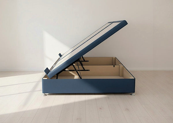Blue fabric side lift ottoman bed with gas-assisted mechanism, open to reveal spacious underbed storage.