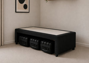 Single black upholstered divan base with hidden suitcase storage, non-slip top, and black luggage underneath.