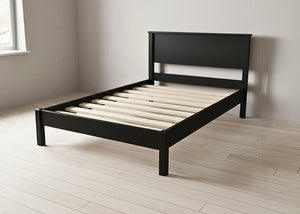 Stavern Pine Bed, a black painted wooden bed frame with solid slats, in a modern minimalist style.