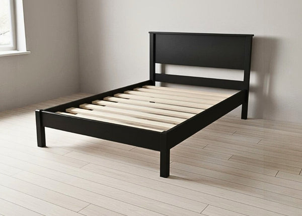 Stavern Pine Bed, a black painted wooden bed frame with solid slats, in a modern minimalist style.