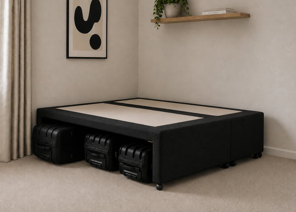 Black upholstered divan base with hidden suitcase storage, non-slip top, and black luggage underneath.