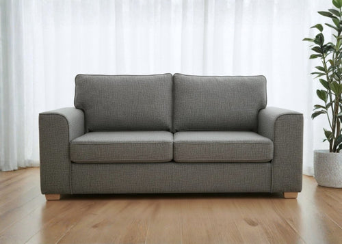 Titan sofa finished in grey fabric shown with light wood feet